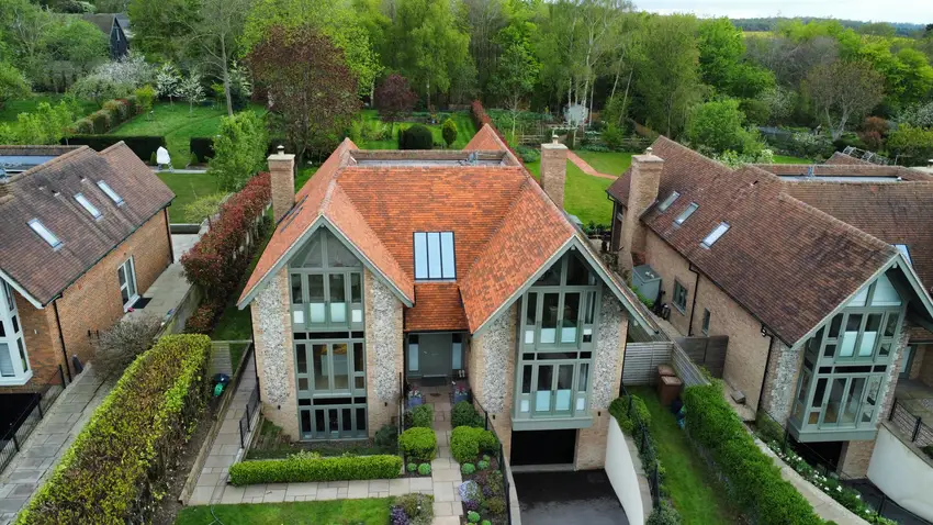 Orange-red roof tiles above the twin gables of the same Watlington home after cleaning, photographed from a higher angle
